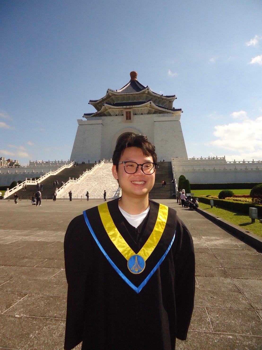 Jonathan wearing his graduation gown in front of Chiang Kai-shek Memorial Hall